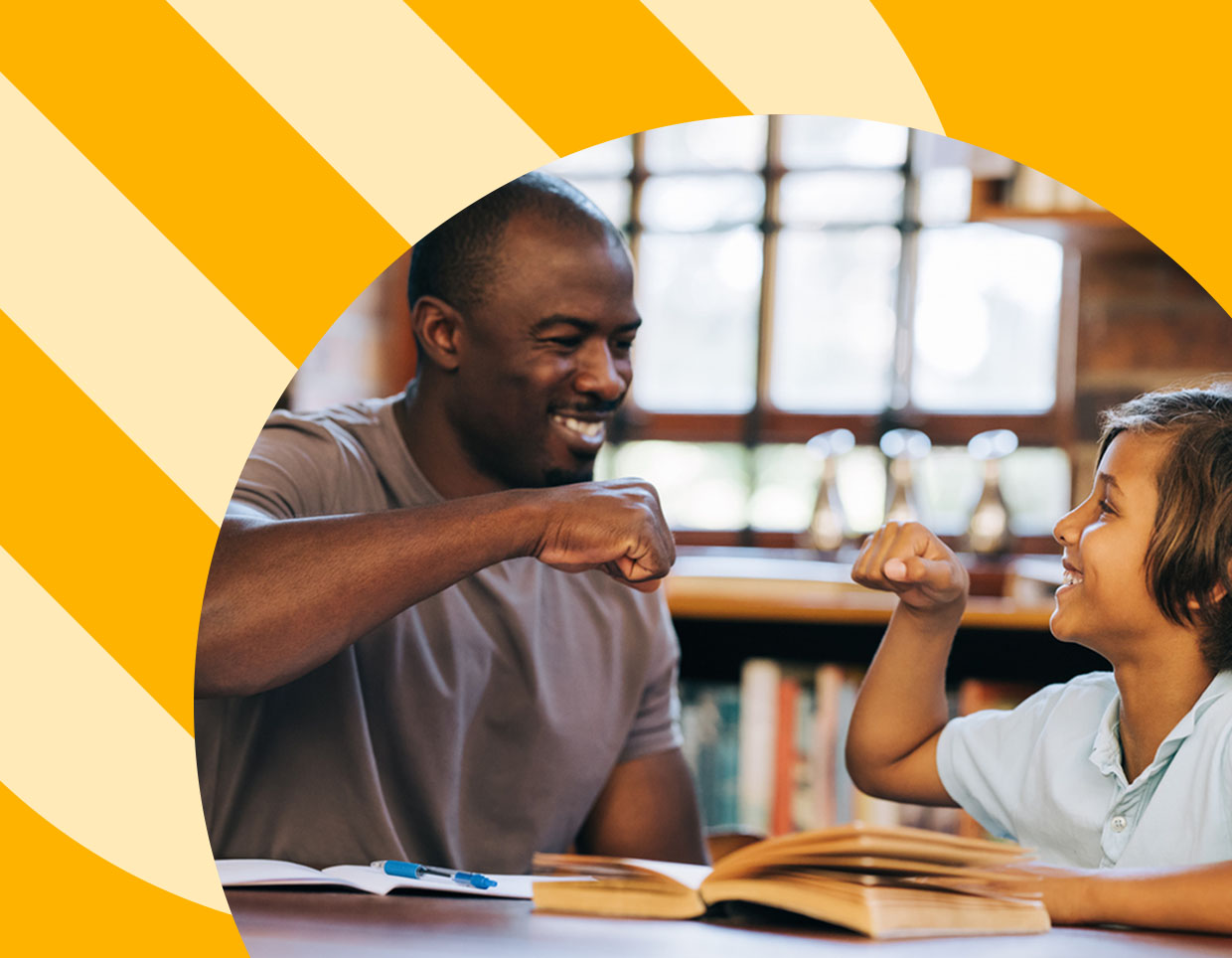 A joyful moment of connection between a smiling dark skin toned adult and medium skin toned child, as they exchange a playful fist bump over their study materials, highlighting a supportive educational environment.