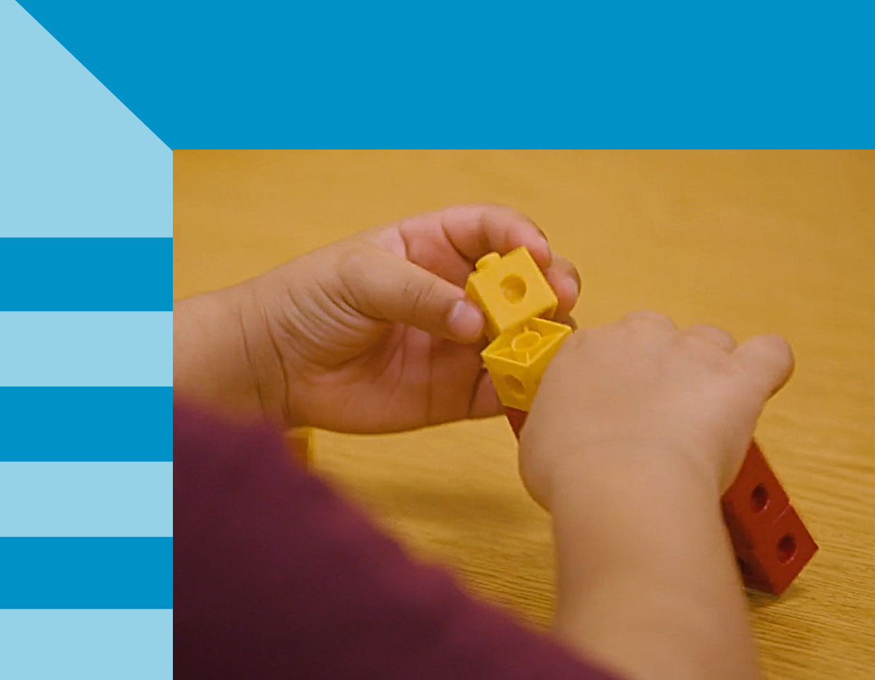 A medium skin toned child using with colorful interlocking counting blocks on a wooden surface, fostering creativity and math skills.